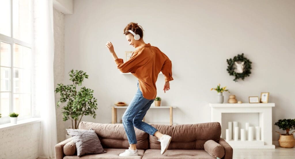 Cheerful woman listening to music and dancing